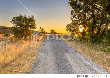 Sunrise over road in Causse Blandas 74573021