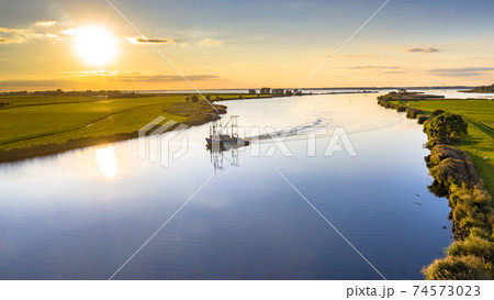 Aerial view of river with ship at sunset Aerial view of river with ship at sunset 74573023