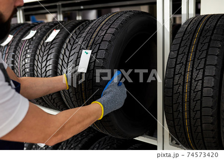 retirement man touching and choosing for buying a tire, measuring rubber car wheel 74573420