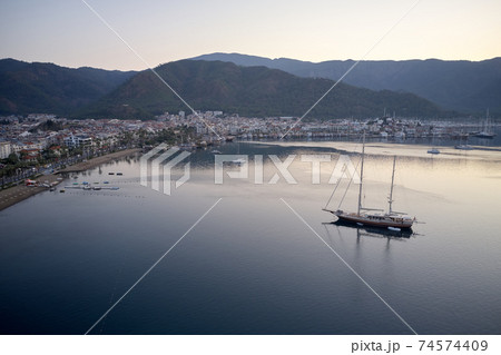 Aerial view of boats, mountains and city at sunset. Aerial view of boats, mountains and city at sunset. 74574409