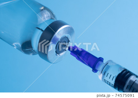 Close-up of filling a syringe with vaccine. A syringe with a needle draws the medicine. 74575091