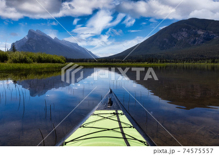 Kayaking in a beautiful lake surrounded by the Canadian Mountain Kayaking in a beautiful lake surrounded by the Canadian Mountain 74575557