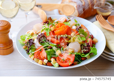 メイン料理としてのボリューミーなシーフードサラダ 海鮮野菜サラダ スモークサーモン 帆立ほか の写真素材