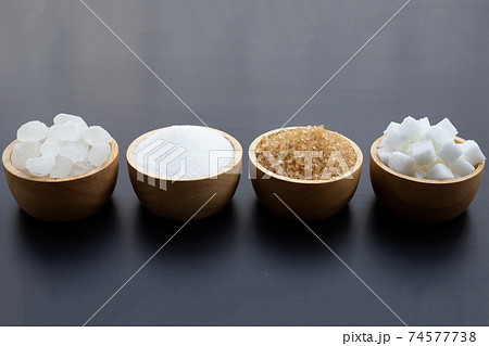 Various types of sugar on dark background. Various types of sugar on dark background. 74577738
