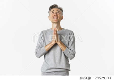 Image of nervous middle-aged man begging God, looking up and pleading for something, supplicating over white background 74579143
