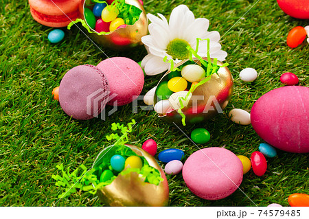 Close up photo of colored Easter eggs and candies on grass Close up photo of colored Easter eggs and candies on grass 74579485