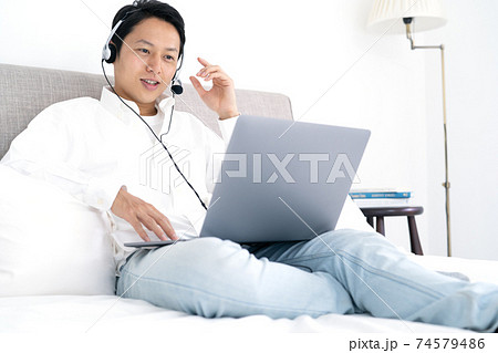 自宅でビデオチャットをする若い男性 74579486