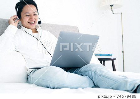 自宅でビデオチャットをする若い男性 自宅でビデオチャットをする若い男性 74579489