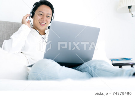 自宅でビデオチャットをする若い男性 74579490