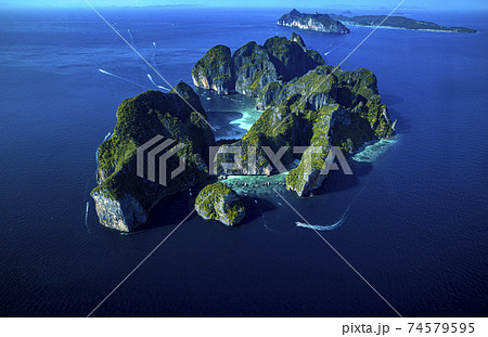 Top view of isolated rocky tropical island with turquoise water and white beach. Top view of isolated rocky tropical island with turquoise water and white beach. 74579595