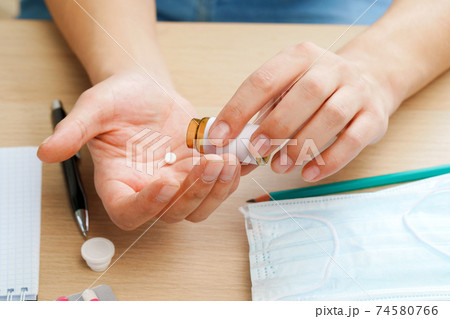 Close up of male hands pouring out the pills from the medicine bottle 74580766