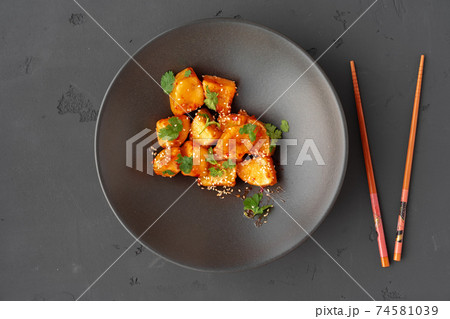 Deep fried eggplant with herbs and sesame in black ceramic bowl 74581039