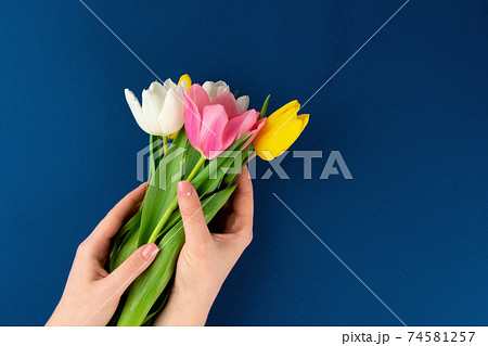 Woman hands with manicure holding colorful tulips 74581257