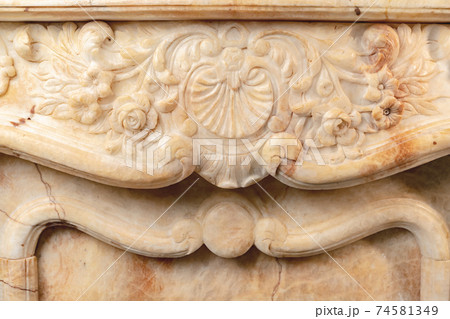 Carved patterns on stone luxury fireplace close up Carved patterns on stone luxury fireplace close up 74581349