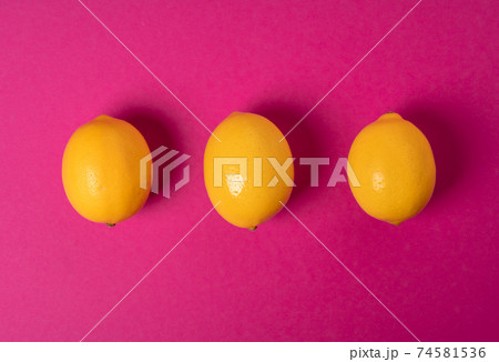 Ripe lemons on bright pink paper background Ripe lemons on bright pink paper background 74581536