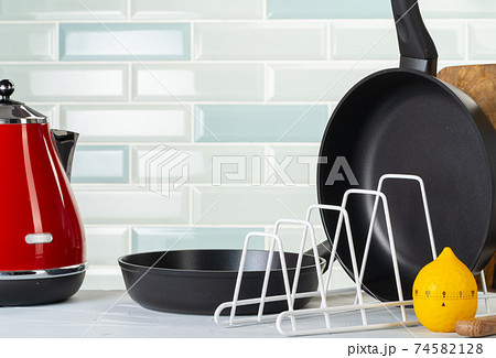 Clean and dry cooking pans on a kitchen counter 74582128