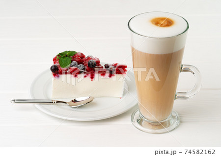 Cup of latte coffee with piece of berry cheesecake 74582162