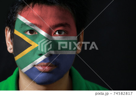 Portrait of a man with the flag of the South Africa painted on his face on black background Portrait of a man with the flag of the South Africa painted on his face on black background 74582817
