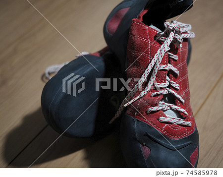 フローリング上の赤い紐締めタイプのボルダリンググシューズ フローリング上の赤い紐締めタイプのボルダリンググシューズ 74585978