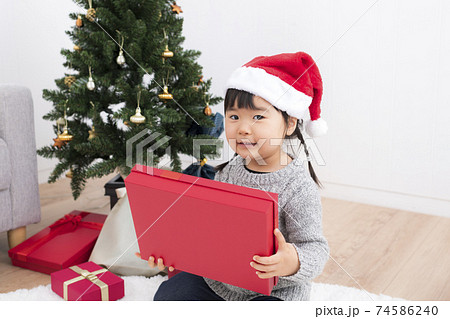 クリスマスプレゼントを貰って喜ぶ女の子の写真素材