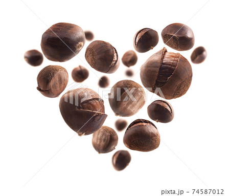 Ripe chestnuts in the shape of a heart on a white background 74587012
