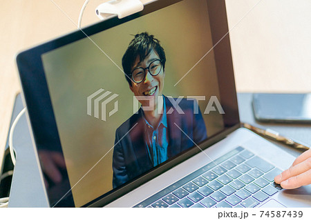 パソコン画面に映っているオンライン会議の相手 パソコン画面に映っているオンライン会議の相手 74587439