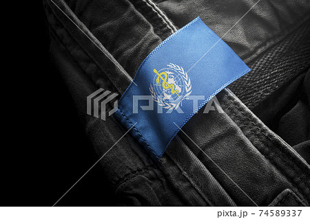 Tag on dark clothing in the form of the flag of the World Health Organization WHO Tag on dark clothing in the form of the flag of the World Health Organization WHO 74589337