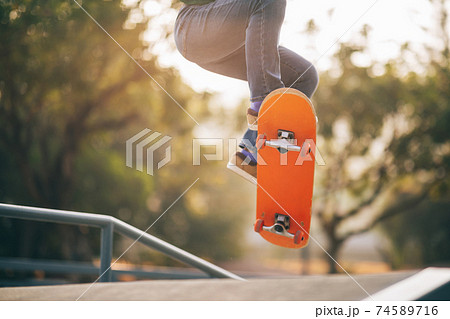 Asian woman skateboarder skateboarding at skatepark 74589716