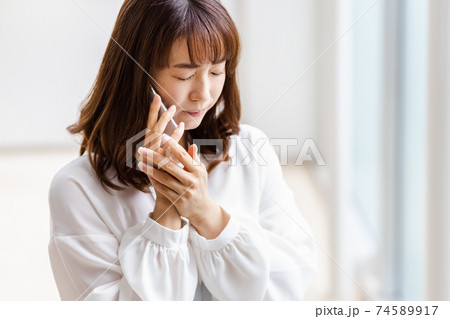スマホを耳にあて悩ましい表情をみせる女性 スマホを耳にあて悩ましい表情をみせる女性 74589917