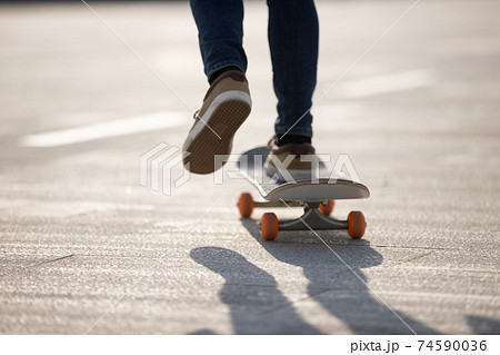 Skateboarder skateboarding outdoors on sunny morning Skateboarder skateboarding outdoors on sunny morning 74590036