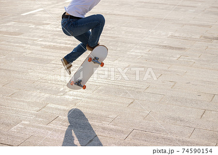 Asian woman skateboarder skateboarding in modern city 74590154