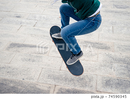 Asian woman skateboarder skateboarding in modern city Asian woman skateboarder skateboarding in modern city 74590345