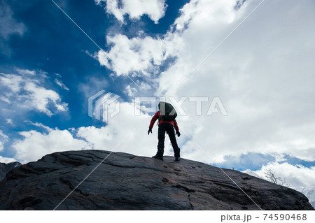 Woman hiker enjoy the view on winter mountain top cliff edge 74590468