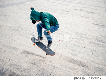 Asian woman skateboarder skateboarding in modern city 74590470
