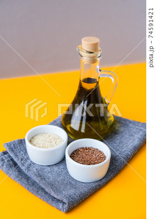Sesame and flax seeds with oil in glass bottle. Healthy food concept. Vegan keto diet. Linseed oil. Sesame oil Minimalistic concept in isometric style in trendy colors. Sesame and flax seeds with oil in glass bottle. Healthy food concept. Vegan keto diet. Linseed oil. Sesame oil Minimalistic concept in isometric style in trendy colors. 74591421