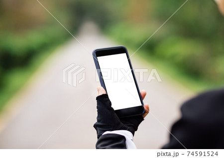 Cyclist use smartphone when riding mountain bike on forest trail 74591524