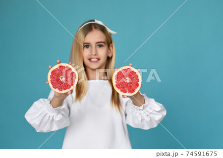 cute little child girl holding fresh juicy grapefruit 74591675