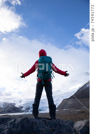 Successful woman backpacker hiking in winter mountains 74591772