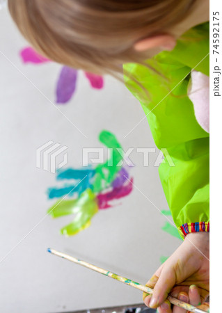 Little girl using watercolour at home during the pandemic lockdown 74592175