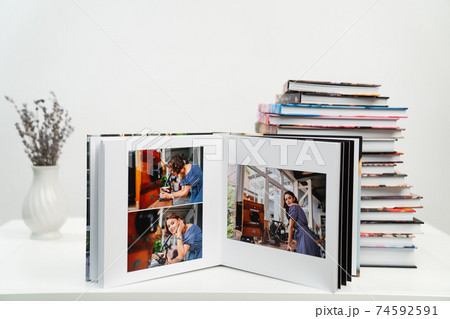 open photobook from photo shoots of woman with a microscope. stack of books 74592591