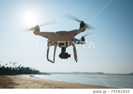 Drone flying in the air under at seaside Drone flying in the air under at seaside 74592850