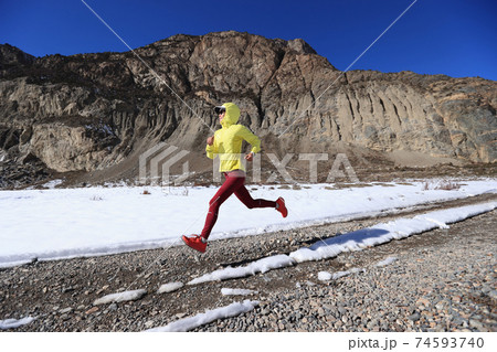 Woman trail runner cross country running in winter nature Woman trail runner cross country running in winter nature 74593740