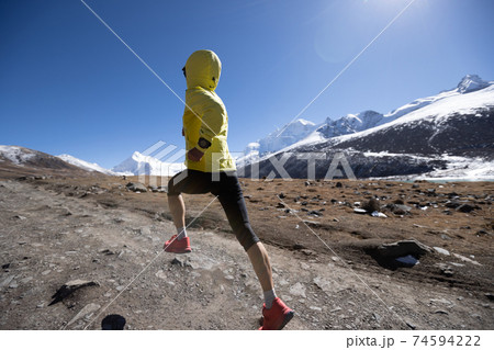 Woman trail runner cross country running in winter mountains 74594222
