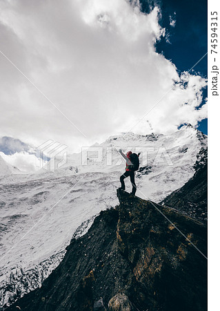 Woman hiker enjoy the view on winter mountain top cliff edge 74594315