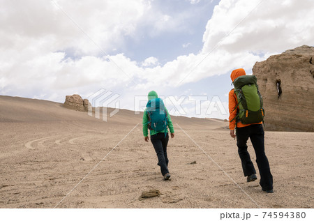 Two women hikers hiking on sand desert 74594380