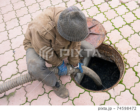 man pumping sewage from the hole man pumping sewage from the hole 74598472