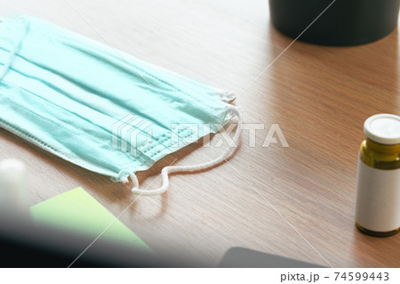 Medical protective mask on office table. Coronavirus spread prevention concept Medical protective mask on office table. Coronavirus spread prevention concept 74599443