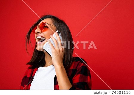 Closeup photo of attractive positive laughing young brunet woman wearing stylish red shirt white t Closeup photo of attractive positive laughing young brunet woman wearing stylish red shirt white t 74601116