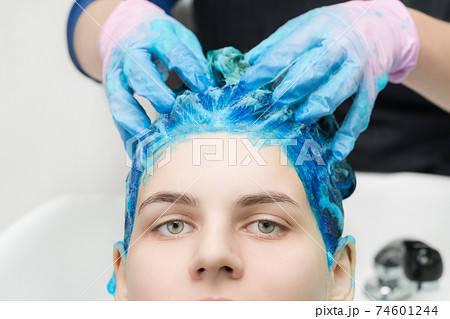 Hairstylist hands in gloves washing hair with shampoo and conditioner in professional beauty salon Hairstylist hands in gloves washing hair with shampoo and conditioner in professional beauty salon 74601244