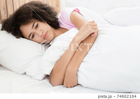 Sad, depressed young african american lady in bed without sleepy feeling desperate 74602104